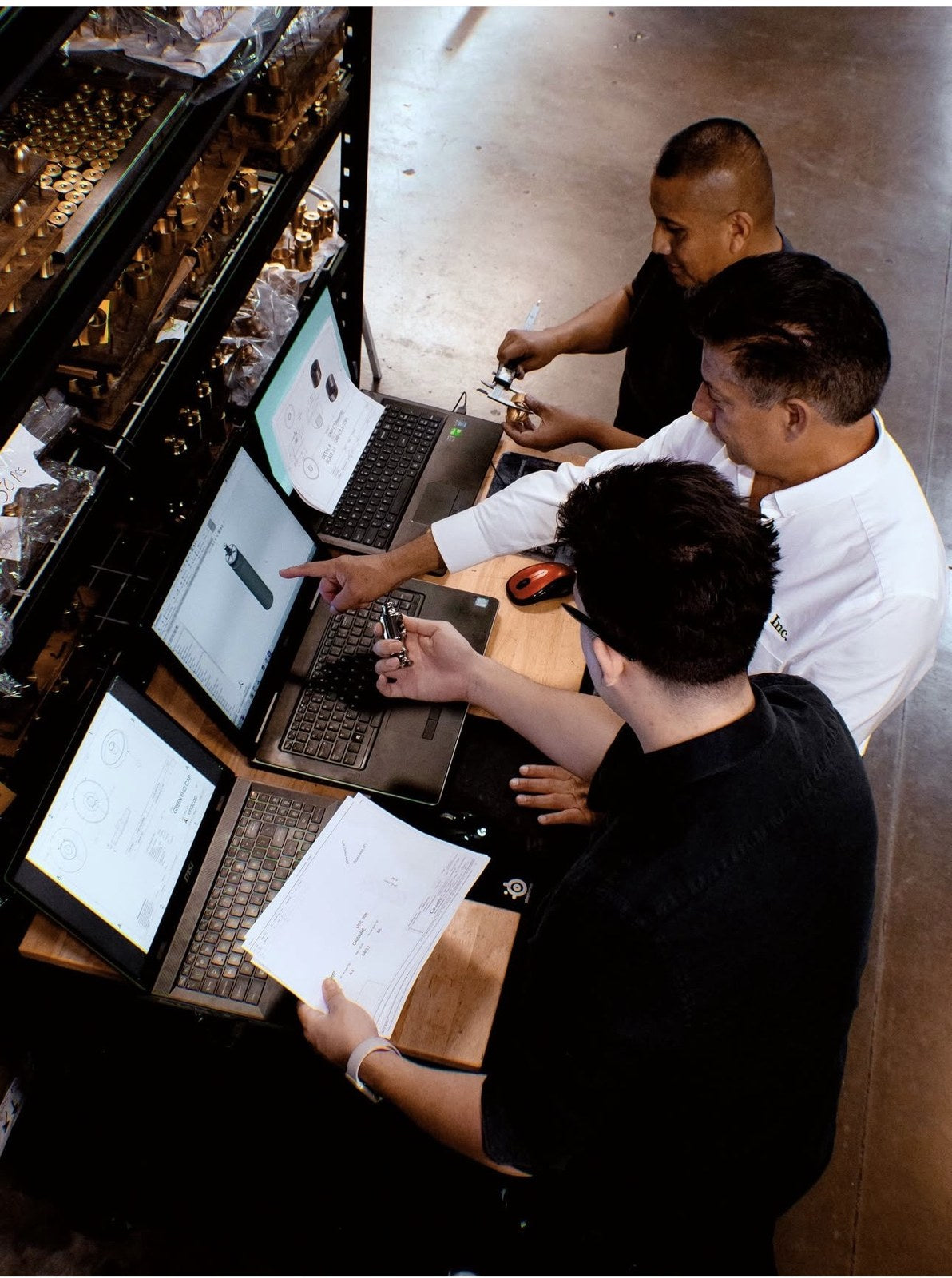 Freddy Vidal and his engineering team reviewing CAD drawings and measuring machined components at the workshop